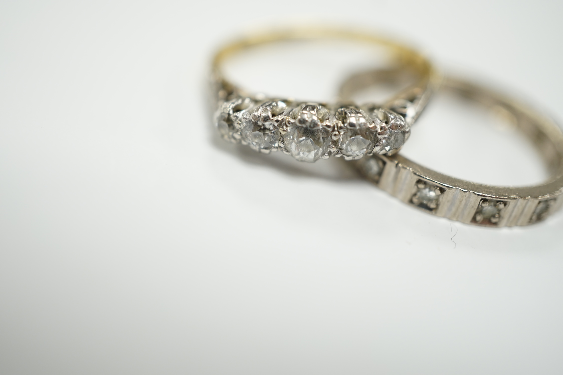 A 750 white metal and diamond chip set full eternity ring and an 18ct and graduated five stone diamond chip set ring, gross weight 6.6 grams.